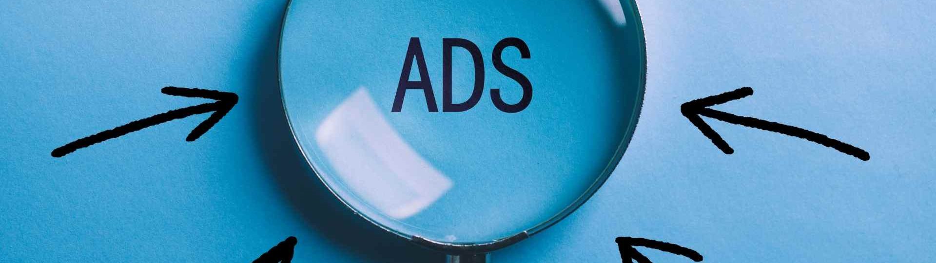 Magnifying glass highlighting online ads with arrows pointing toward the campaign