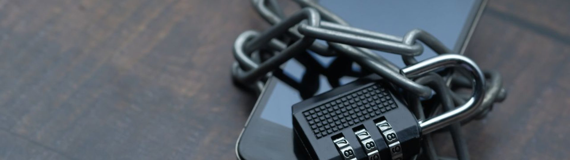 Smartphone wrapped in a metal chain and secured with a combination padlock