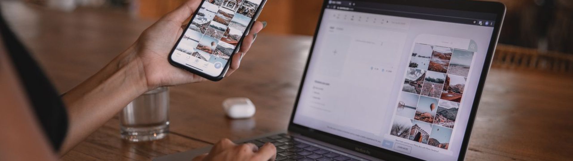 Person holding a smartphone while reviewing a grid of photos on a laptop