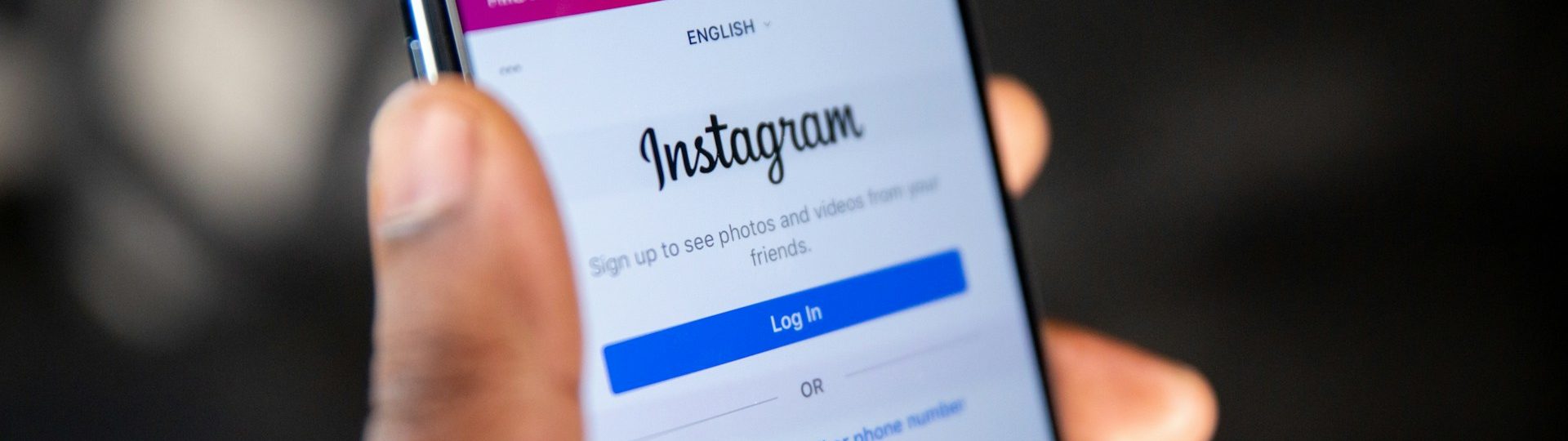 Person holding a smartphone displaying the Instagram login page