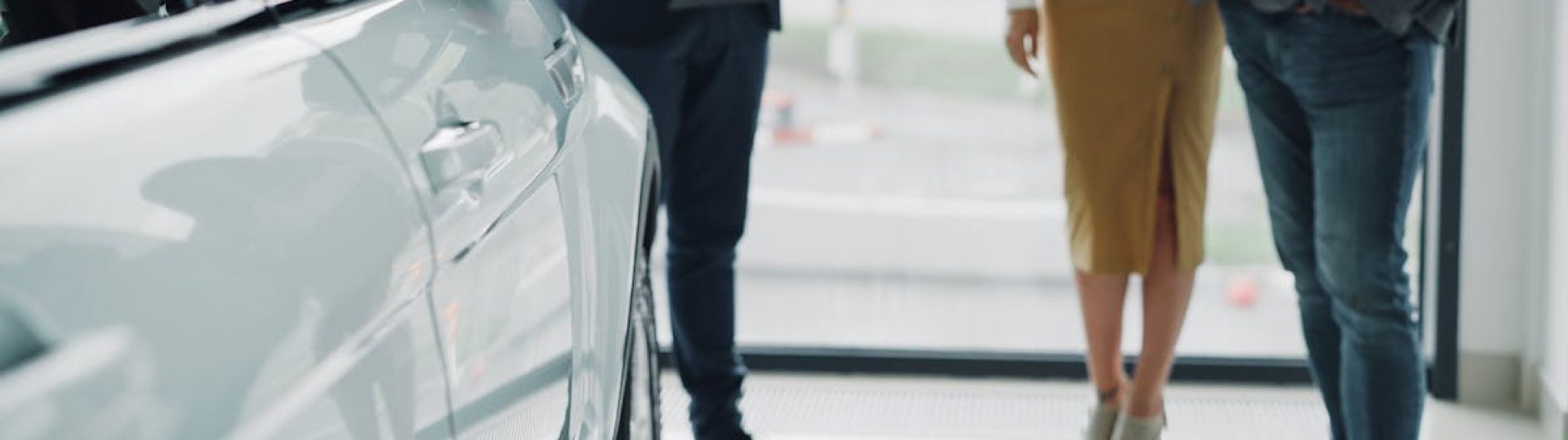 Professional consultation at a car dealership with businesspeople discussing car options.