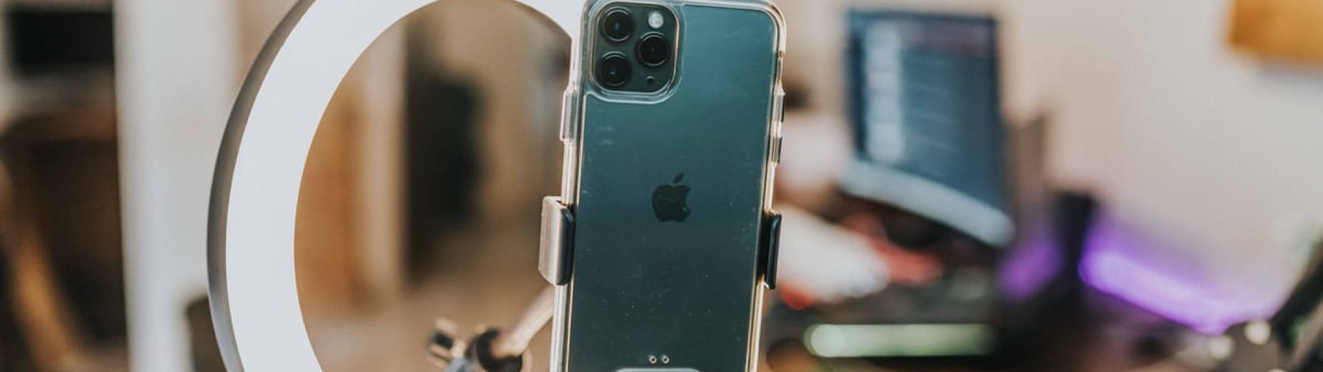 Smartphone mounted in ring light for content creation in modern workspace.