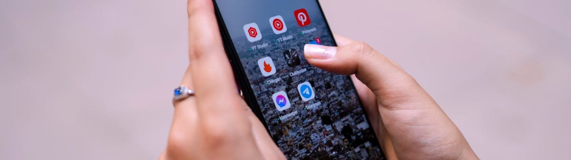 Close-up of hands holding a smartphone displaying social media apps, emphasizing digital connectivity.