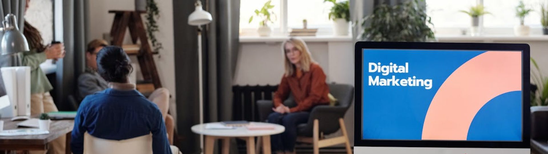 A diverse team engages in a digital marketing meeting in a stylish office setting.
