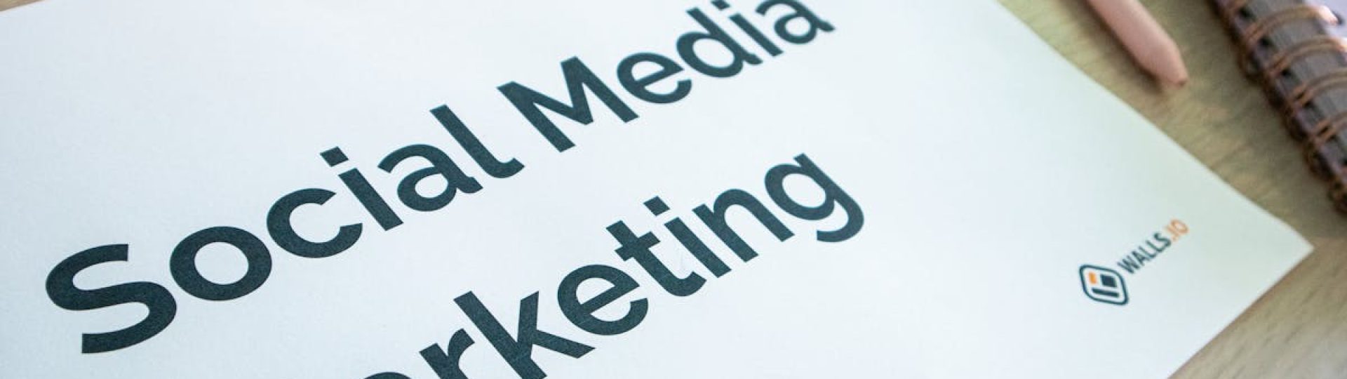 Close-up of a social media marketing document on a desk with a pen and notebook.