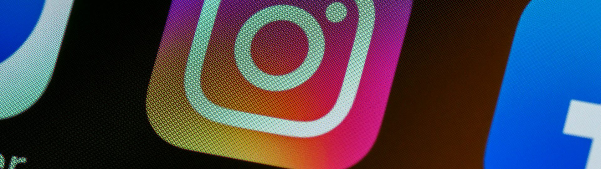 Close-up of the Instagram app icon on a smartphone screen next to other social media apps