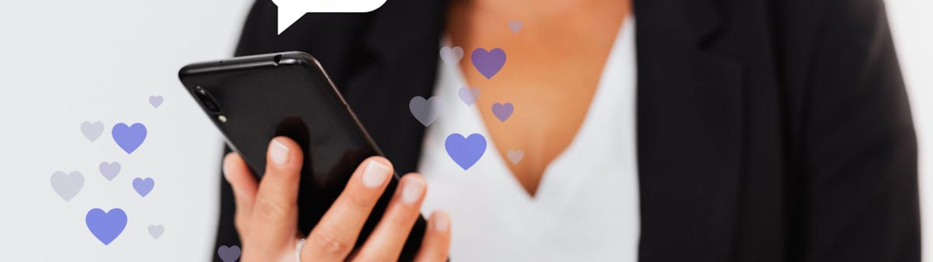 Close-up of a woman holding a smartphone with floating heart icons, illustrating digital engagement.