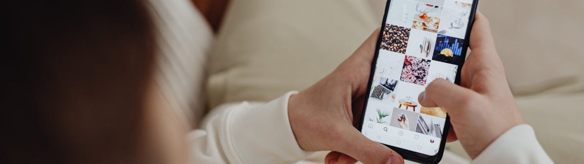 Person using smartphone to browse Instagram indoors, showing social media engagement.