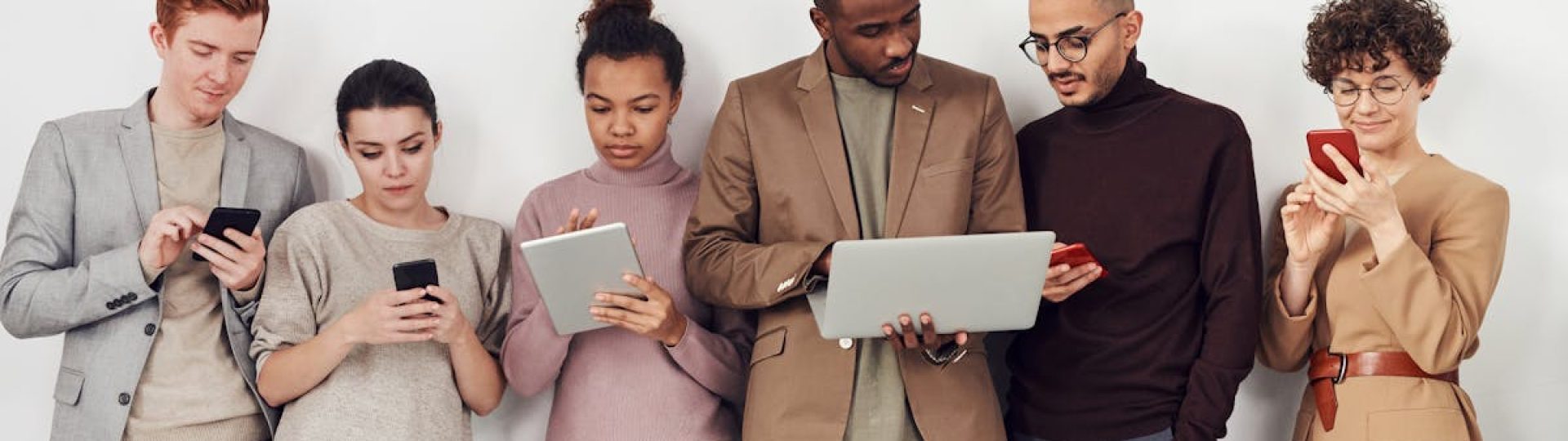 A diverse group of young adults using mobile devices. Perfect for business and technology themes.