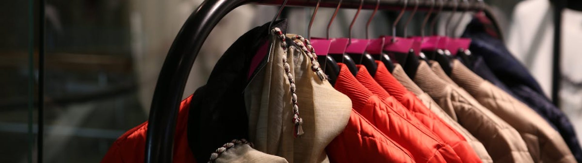 A variety of colorful jackets hanging on a clothes rack in a stylish store.