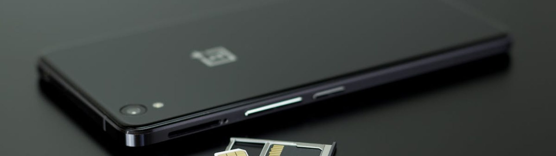 Close-up of a smartphone with a SIM card and memory card, showcasing modern technology.