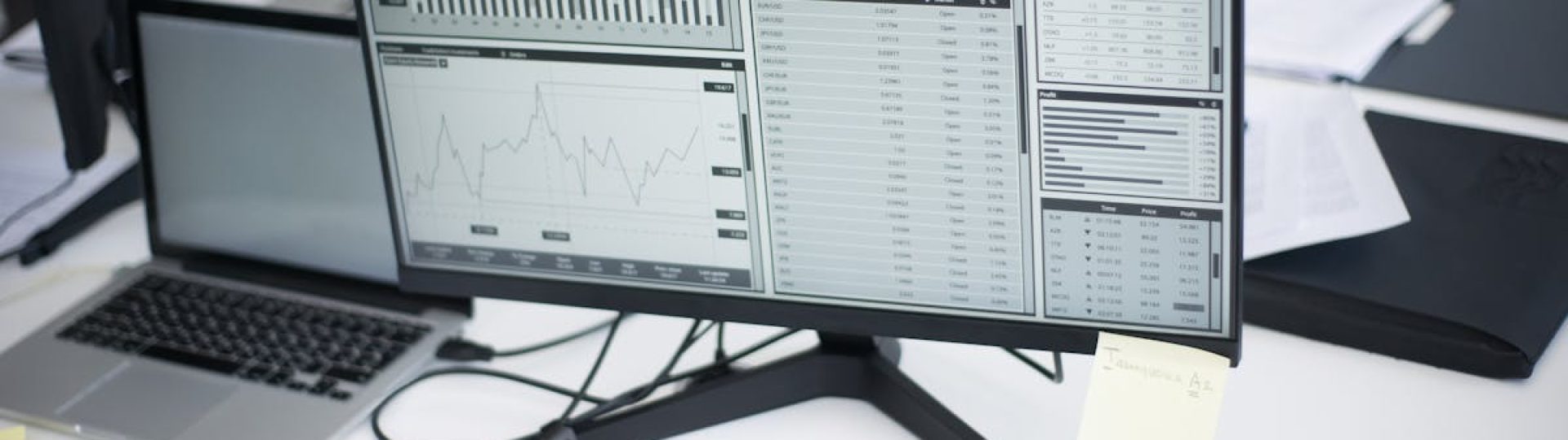 A professional workspace featuring computers and analytical graphs on a monitor, symbolizing modern business environment.