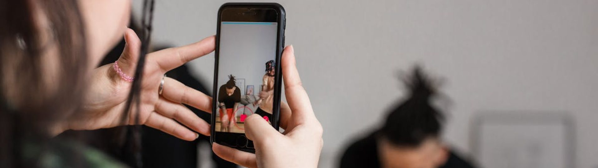 Close-up of a person recording a video with a smartphone indoors, focusing on creative content creation.