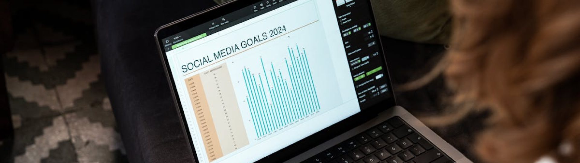A woman reviewing 2024 social media goals on a laptop at home.