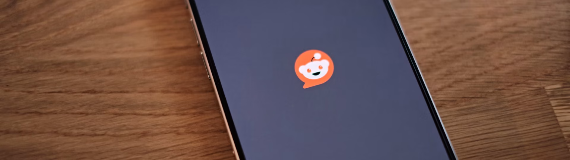 reddit logo on black background of the phone