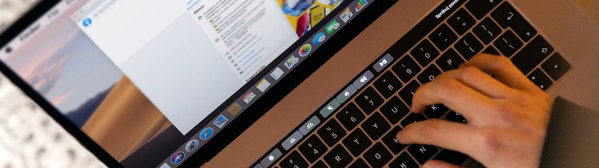 Hands typing on a laptop at a desk, engaging in online work, and navigating social media.