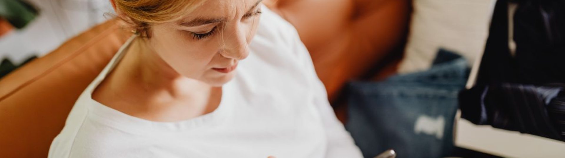 Woman sitting on a sofa using a smartphone at home.