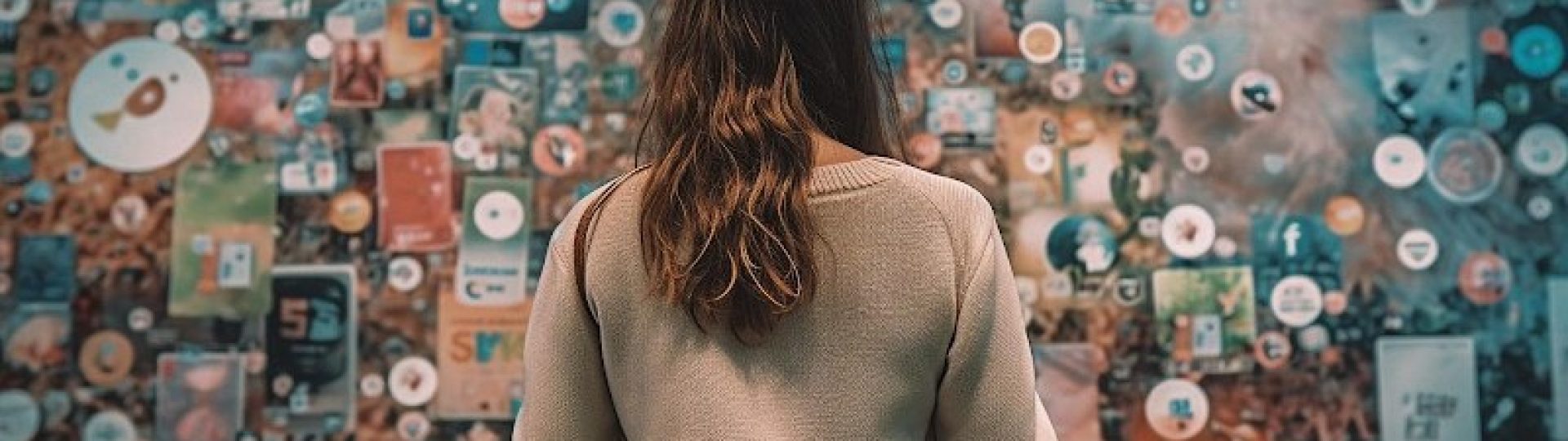 Woman looking at a wall filled with social media icons and digital content